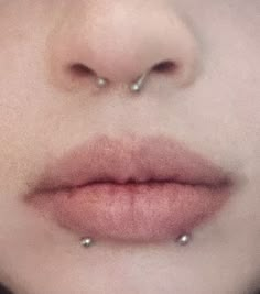 a woman's nose with two piercings on her left side and the middle part of her lip