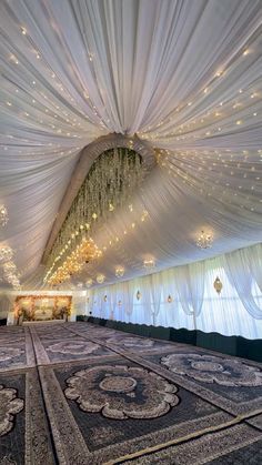 the ceiling is decorated with white drapes and lights