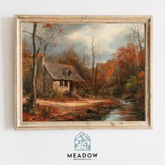 a painting hanging on the wall next to a white wall with a house and stream in it