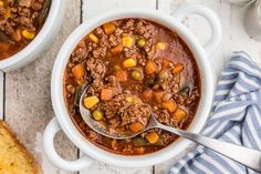 two white bowls filled with chili and ground beef soup on top of a wooden table