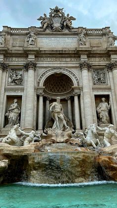 a fountain with statues and water in front of it