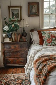 a bed sitting in a bedroom next to a window with lots of pillows on top of it