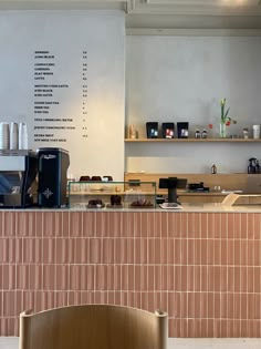 a coffee shop with a counter and chairs in front of the counter, along with menus on the wall