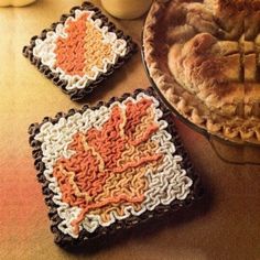 three crocheted pies sitting on top of a table next to a bowl of food