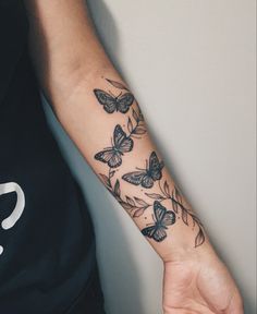 a person with a butterfly tattoo on their left arm and the other arm is black