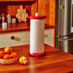 a kitchen counter with oranges and a paper towel dispenser