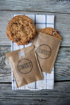 two cookies sitting next to each other on top of a napkin and bag with the word sweet