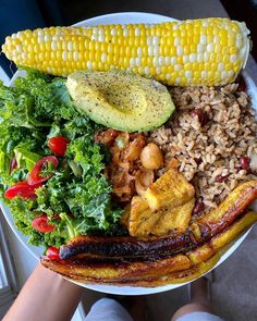 a white plate topped with lots of food and veggies next to a window