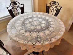 a table with two chairs and a doily on it