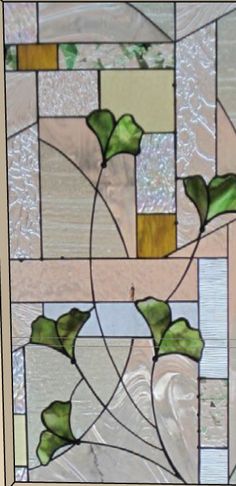 a stained glass window with green leaves on it