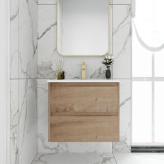 a bathroom with marble walls and flooring has a wooden cabinet under the mirror that is above it