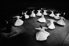 a group of women in long dresses dancing on a stage with their arms outstretched and legs spread out