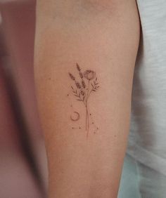 a woman's arm with a flower and moon tattoo on the left side of her arm