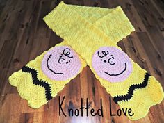 a crocheted rug with two smiley faces on it and the words knitted love written below