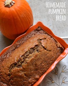 a loaf of pumpkin bread sitting on top of a table next to an orange pumpkin