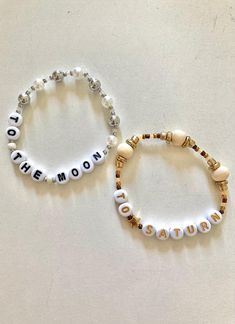 two beaded bracelets with the words to the moon and love written on them