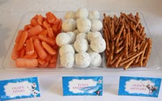 there is a tray with carrots, pretzels and other snacks