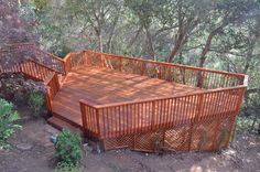 a wooden deck surrounded by trees and bushes