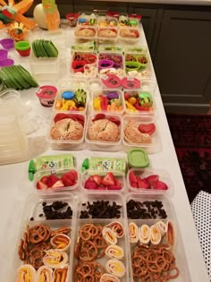 a table topped with plastic containers filled with different types of food and snacks on top of it