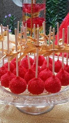 a bowl filled with red cake pops on top of a table