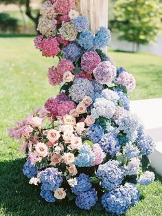 a bunch of flowers that are sitting in the grass on some grass and one is pink, blue, and white