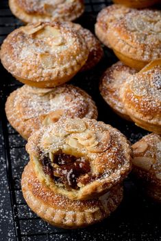 several pastries on a cooling rack with powdered sugar and jelly in the middle