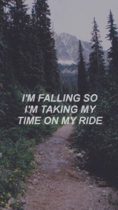 a dirt road surrounded by trees with the words i'm falling so i'm taking my time on my ride