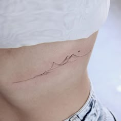 a woman's stomach with a small wave tattoo on her lower side ribcage