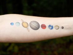 a person's arm with the solar system on it and eight planets painted on it