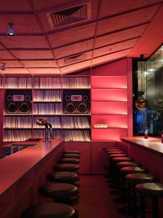 an empty bar with lots of stools and speakers