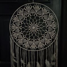 a white dream catcher hanging from a door