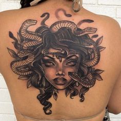 the back of a woman's head with snakes on her shoulder and eyes closed