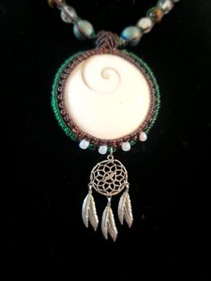 Hi, I'm Ravi Scott, the artisan behind Himmapan Jewelry. I'm delighted to showcase this Shiva Eye Pendant Necklace with Dream Catcher Charm, a one-of-a-kind piece that marries Earth's natural beauty with elements of boho, hippie, and psytrance style. This necklace features a Shiva Eye pendant, a symbol of protection and wisdom, also known as the snail operculum. Accompanying the Shiva Eye is a beautiful charm inspired by Native American dream catchers, revered for their spiritual significance and protective properties. The necklace also incorporates stone beads, adding an authentic, earthy touch to the design. This piece reflects my passion for creating jewelry that draws inspiration from nature and cultural traditions, offering a unique blend of aesthetics and symbolism. Symbole Protection, Dream Catcher Native American, Shiva Eye, Eye Pendant Necklace, Creating Jewelry, Eye Pendant, Hippie Jewelry, Dream Catchers, American Dream