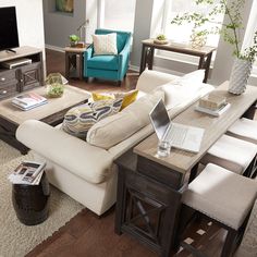 a living room filled with furniture and a flat screen tv on top of a wooden table