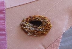 a small bird's nest sitting on top of a pink cloth