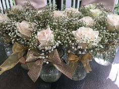 white roses and baby's breath in a mason jar on a dining room table