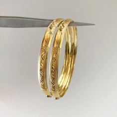 "Please drop a message saying \"Discounted Price\" & we'll reply you with a lower price, if any discounts are available. As these gold bangles are very light in weight, after making these bangles, we put a protective metal bangle on the inner surface of the original gold bangles, as shown in the 4th image, this provides strength & shape to the bangles. Please Note:- The bangles are made out of Real Solid Gold & the metal bangles are just for support & durability. All Sizes availa Metal Bangles, Gold Bangles For Women, The Bangles, Yellow Gold Bangle, Precious Jewels, Gifts For My Boyfriend, Indian Designer, Cuban Chain, Vintage Bracelets