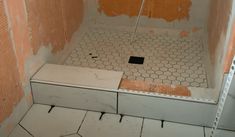 an unfinished bathroom with tiled floor and walls