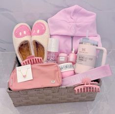 a basket filled with personal care items on top of a floor next to a pink bag