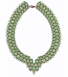 a necklace with green and white beads on it's sides, in the shape of leaves