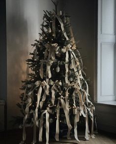 a christmas tree decorated with ribbons and lights