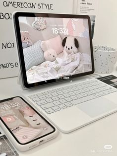 an open laptop computer sitting on top of a desk next to a phone and tablet