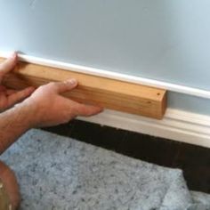 a man is working on the base of a window sill with wood and glue