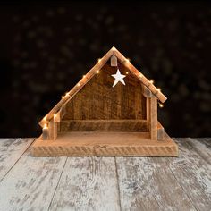 a wooden nativity scene with lights and a star