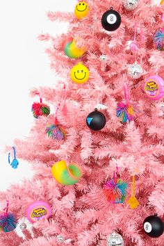 a pink christmas tree decorated with smiley face ornaments