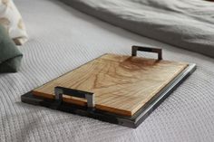 a piece of wood sitting on top of a bed next to a white comforter