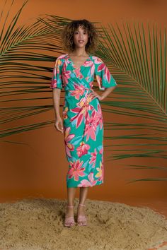 Stay stylish this summer in our Romilly dress with a v-neck, flutter sleeves, and a beachy floral print. The faux wrap design and midi length make it perfect for any summer occasion. Chic V-neck Midi Dress With Tropical Print, Tropical Print V-neck Midi Dress For Garden Party, Green Flutter Sleeve Summer Dress, Green Tropical Print Summer Midi Dress, Green Midi Dress With Surplice Neckline For Beach, Summer Vacation Wrap Dress With Surplice Neckline, Summer Midi Dress With Vibrant Green Print, Green Flutter Sleeve Dress For Vacation, Summer Multicolor Midi Dress With Surplice Neckline