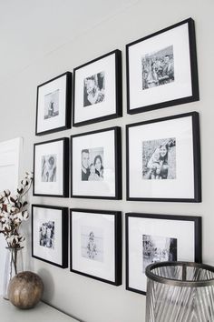 black and white photos are hung on the wall above a vase with flowers in it