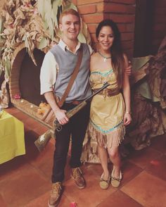 a man and woman standing next to each other in front of a brick fire place