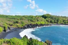 the black sand beach is surrounded by lush green trees